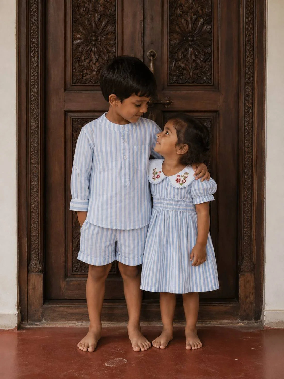 A brother and sister in organic cotton, at the door of a Kerala home on Onam morning